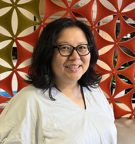 Tonia Lu, wearing a grey shirt and glasses. Brown hair.