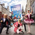 A photograph taken on the Royal Mile in Edinburgh of the Fringe Programme and various characters
