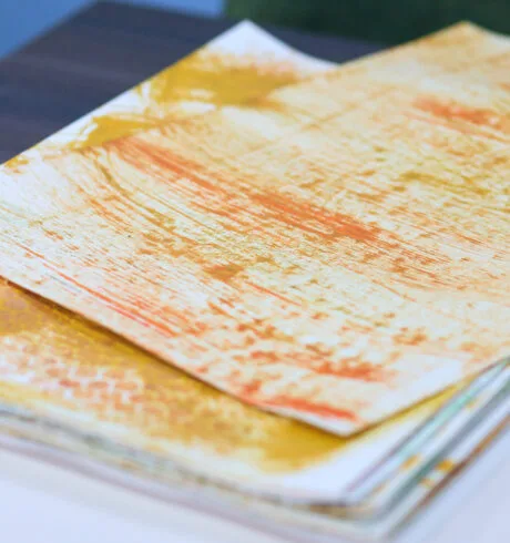 Sheets of paper screen printed with yellow and orange ink.